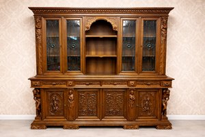 Rozměrná knihovna s bohatou řezbou, figurálními prvky