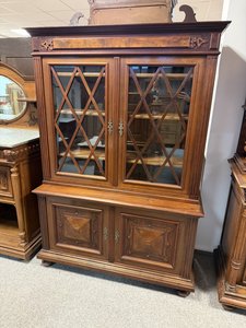 Vitrína s jemně tvarovanou římsou a zdobenými dvířky