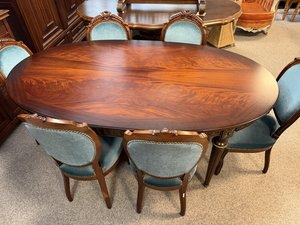 Oválný jídelní stůl s výraznou kresbou dřeva a sadou čalouněných židlí