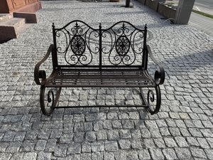 Dvoumístná kovová houpací lavička s bohatě zdobeným opěradlem