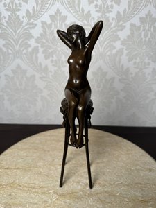 Bronzová socha dívky na barové stoličce