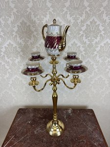 Svícen osazený porcelánovým kávovým servisem