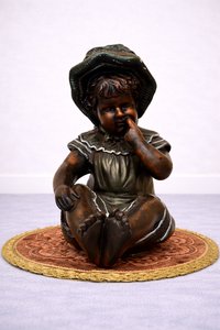 Soška sedícího dítěte s kloboučkem