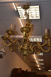 Luxusní mosazný lustr s osmi rameny a zdobenými detaily ve stylu baroko