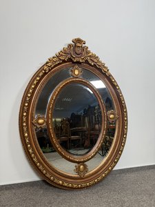 Oválné nástěnné zrcadlo s řezbovaným  rámem