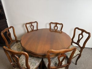 Rozkládací jídelní stůl na centrální noze se šesti čalouněnými židlemi