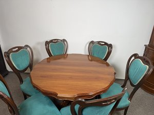 Jídelní stůl se šesti čalouněnými židlemi na centrální noze