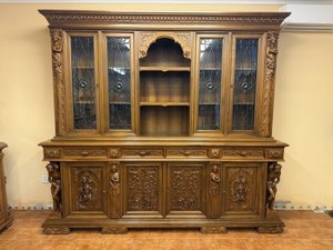 Rozměrná knihovna s bohatou řezbou, figurálními prvky