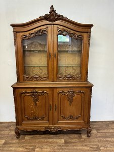 Dubová vitrína s vyřezávanými ornamenty a prosklenými dveřmi