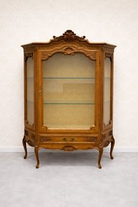 Elegantní vitrína s jemnými řezbami a prosklenými dvířky